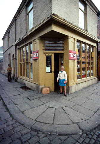 John Bulmer – Old Lady Outside Yellow Shop [Manchester, ENGLAND 1976]