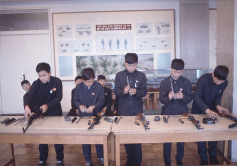 John Bulmer – Boys Strip Kalashnikovs [Pyongyang Museum of culture, NORTH KOREA 1973]